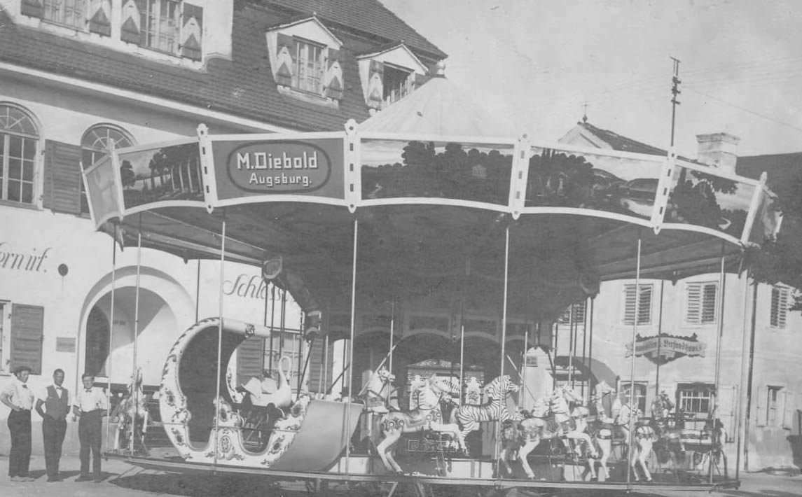 Ein schwarz-weiß Foto eines alten Karussels der Familie Diebold auf einem Stadtplatz in Augburg