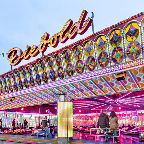 Der Autoscooter bei Tag. Im Vordergrund sieht man den Schriftzug Diebold und im Intergrund die bunte Fläche